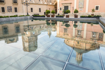 Mirror reflection of the Valencia Cathedral and Royal Basilica of Our Lady of the Abandoned in the pool. Valencia. Spain