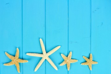 Summer bottom border of star fish on blue wooden background