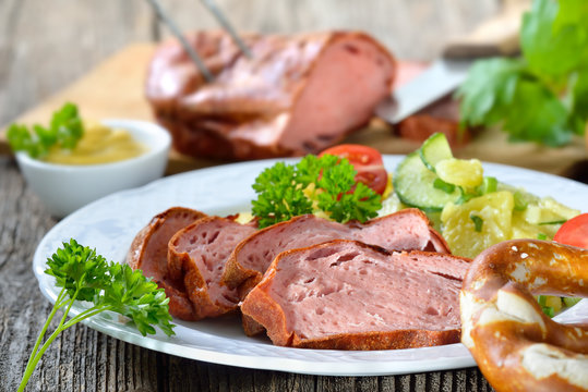 Portion bayerischer, warmer Leberk&auml;s mit Kartoffelsalat, Breze und Senf - Portion of warm Bavarian meat loaf with potato salad, pretzel and mustard