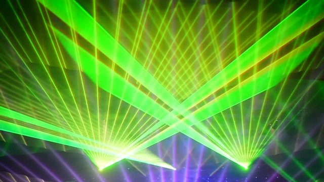 Unrecognizable people watching a beautiful laser show with multicolored lights