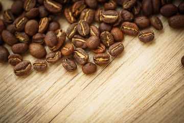 Coffee beans on a wooden desk lit by warm light 