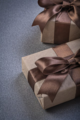Boxed gifts in brown paper on grey background celebrations conce