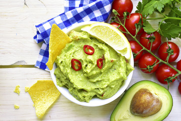 Guacamole in a white bowl on a light background.