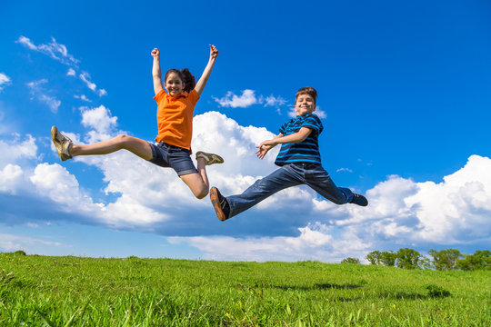 Kids jumping on green hills