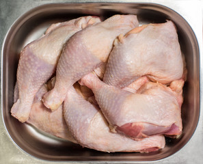 Raw chicken legs in an iron dish