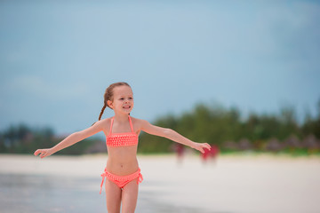 Adorable little girl on beach vacation having fun