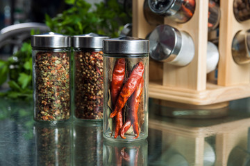 Obraz na płótnie Canvas Dried chili pepper in a glass jar and different spices