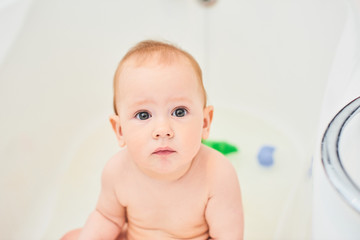Portrait of smiling one year old boy in a white bathroom