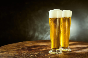 Two ice cold frothy beers in elegant long glasses