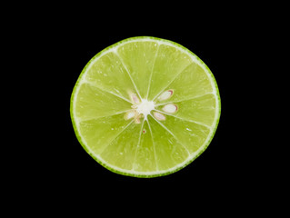 Slice fresh green lime isolated on black background.