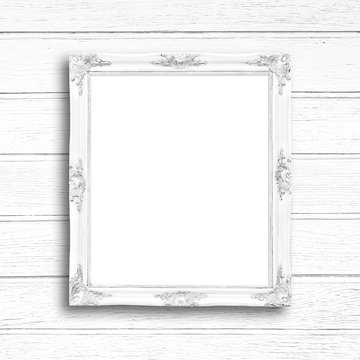 Classic white blank picture frame on white wood wall.