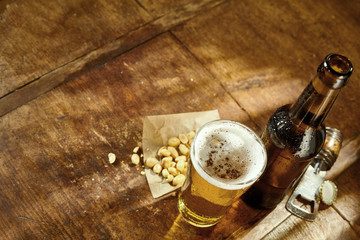 Glass of Beer on Table with Opener and Peanuts
