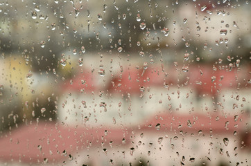 City view through a window with rain drops