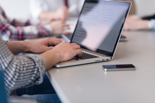 Close Up Of Business Man Hands Typing On Laptop With Team On Mee