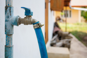 water tap with blue rubber tube