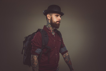 Tattooed bearded man with backpack.
