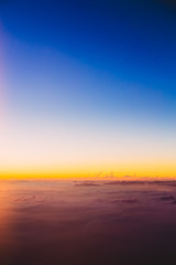 Fototapeta na wymiar Beautiful colorful sunset over mountains from height of airplane