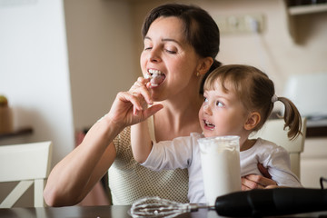 Licking of  whipping cream - mother with daughter