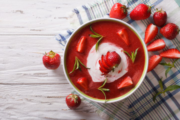 cold strawberry soup with mint and sour cream close-up. Horizontal top view
