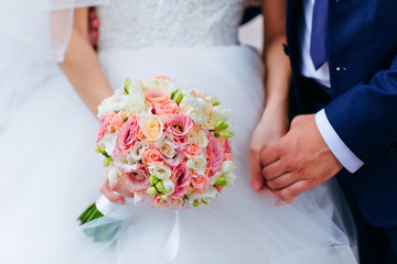 Obraz na płótnie Canvas Bride hold groom by the hand and wedding bouquet. Focus on weddi