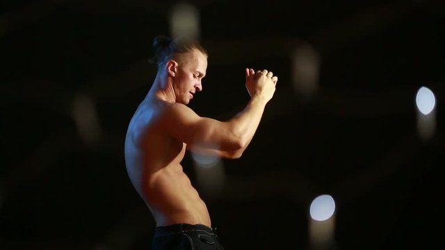 Muscular young sexy naked cute man. male striptease dancing. flashes of light and glare