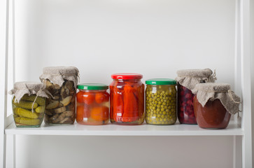 Jars with pickled vegetables on white background