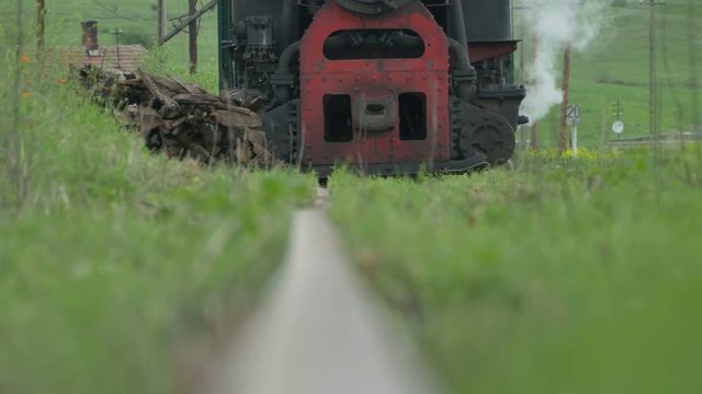 Rail low angle view of a vintage steam locomotive who approach.