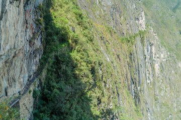 Inca trail carved into a stone wall near Machu Picchu ruins, Peru.