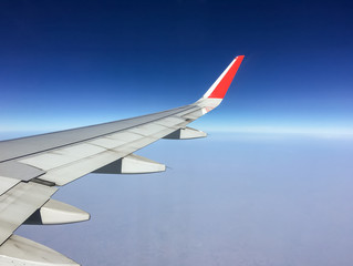 Aerial view from airplane window with blue sky and horizon as background