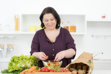 übergewichtige frau macht frischen salat