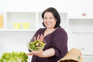 motivierte frau zeigt ihren gesunden salat