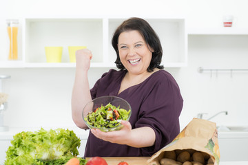 glückliche frau präsentiert ihren hausgemachten salat