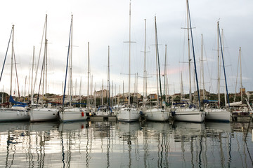 Sailboats in a row next to the pier on the sea