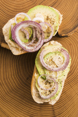 Sandwich with avocado, red onion, salt and herbs