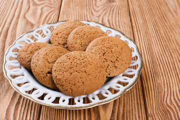 Oatmeal cookies on a plate on a wooden background 