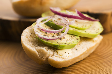 Sandwich with avocado, red onion, salt and herbs