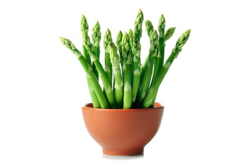 fresh asparagus is in a bowl on white isolated background