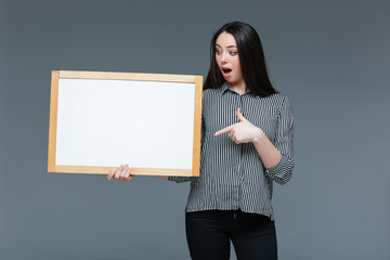 Young businesswoman holding blank board