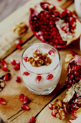 yogurt dessert with walnuts and pomegranate selective focus