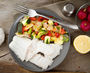 cut vegetables and grilled fish in classic wood