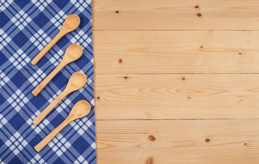 Tablecloth, wooden spoon, on wood textured background