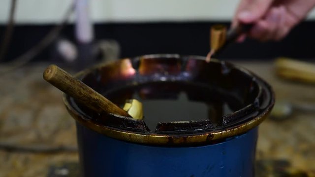 Filling canting with wax for making batik