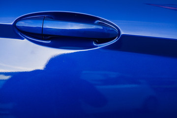 Color image of a blue car door handle.