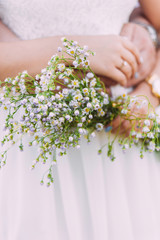 Female and male hands holding wildflowers bouquet.