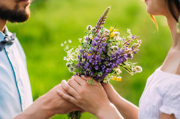 Fototapeta premium Romantic guy gives a girl a rustic bouquet