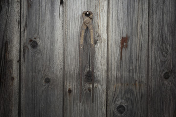 Rusty and grungy old tool on dark wood background