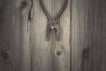 Rusty and grungy old tool on dark wood background