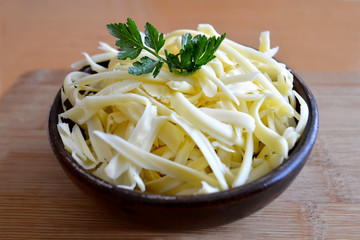 Grated cheese in wooden bowl