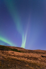 Aurora borealis in the starry night of Iceland, vertical shot 