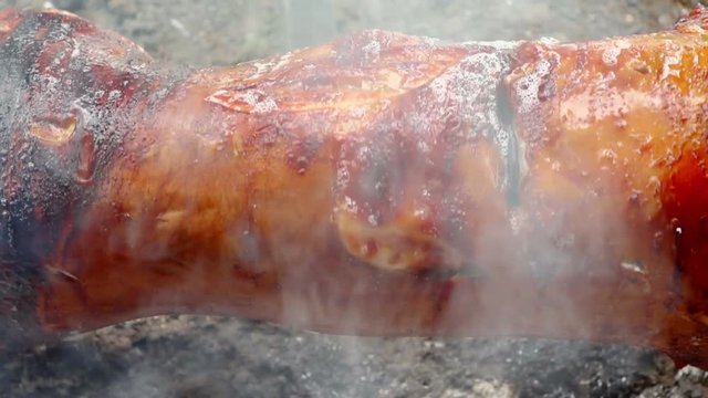 Roasting a pig on a spit outdoors
